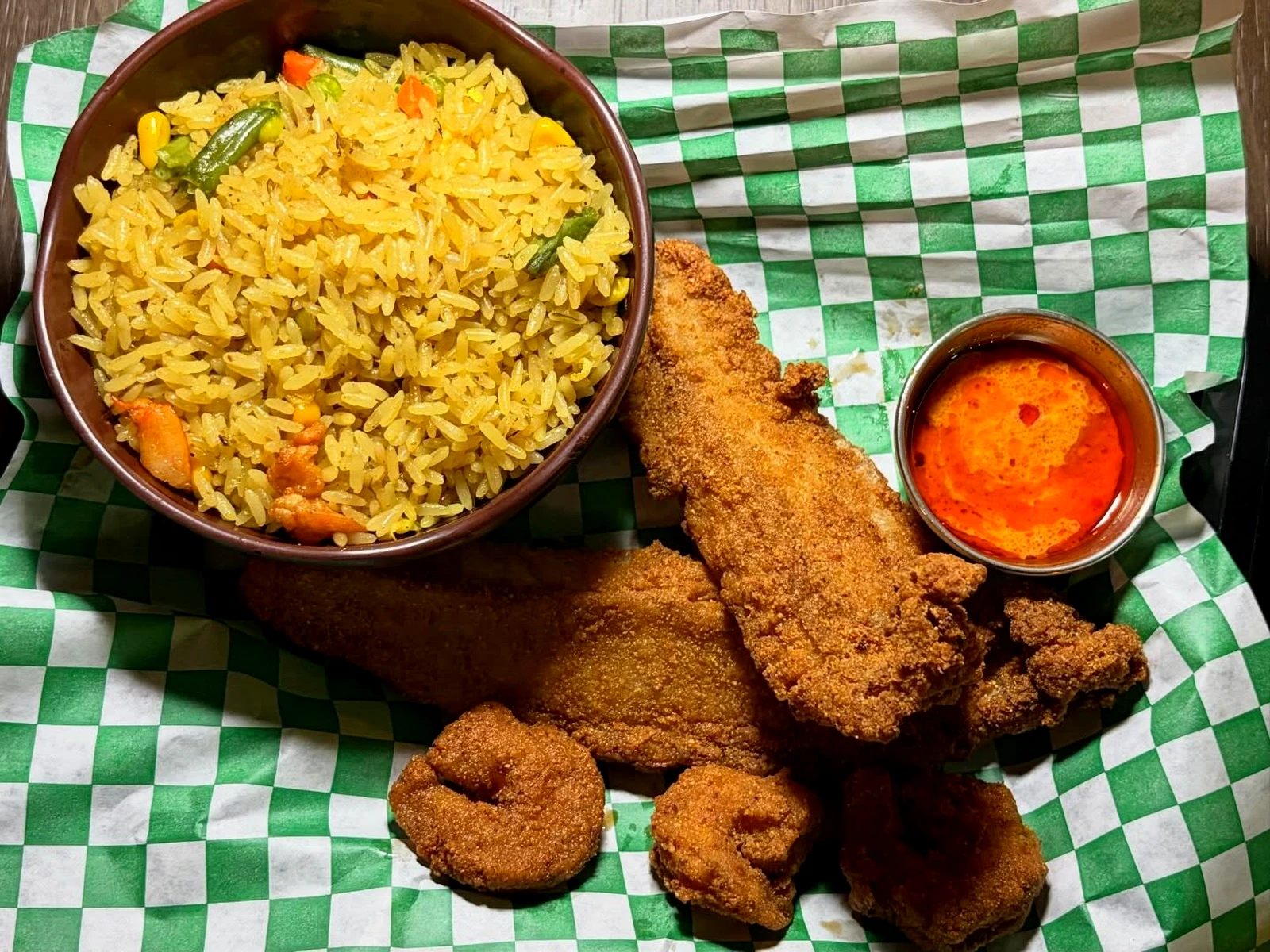 Fried rice, fried fish, shrimp, and pepper sauce at M&M African Kitchen & Bar